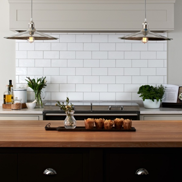 A beautiful kitchen with large format white tiles above the range cooker.