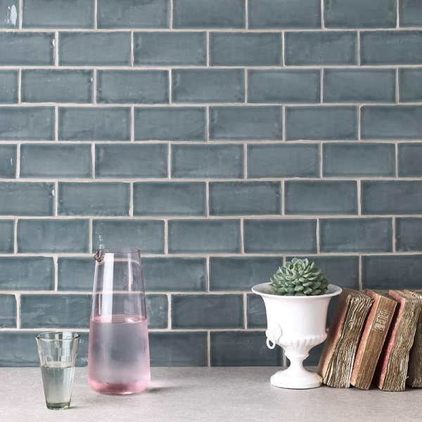 A kitchen sideboard with green-blue small brick tile