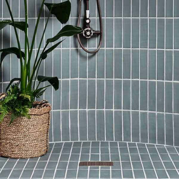 Curved shower with green-grey skinny metro tiles