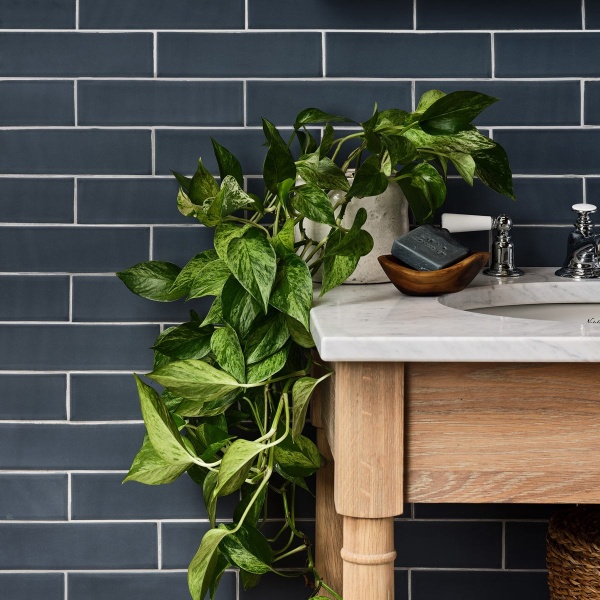 A sink with splashback tiled in deep blue skinny metro tiles